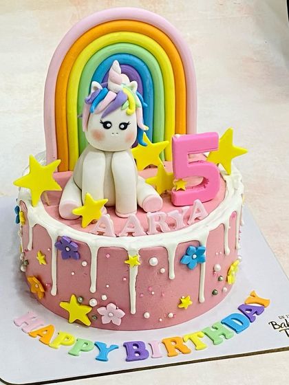 A magical rainbow unicorn cake for Aarya's 5th birthday. This design features a hand-molded unicorn, a colorful rainbow, and fun drip details for a truly enchanting celebration.