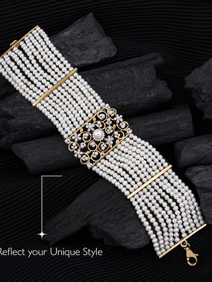 An epitome of luxury and grace. This multi-strand pearl bracelet features a magnificent diamond and pearl clasp, reflecting a timeless elegance. It is the kind of piece that feels both classic and powerful, crafted for those who cherish refined beauty.