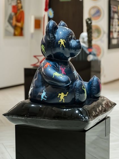 A side profile of the "Ted – Ode To Keith Haring" sculpture, showing its full form and the way the figures wrap around its body.