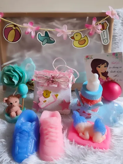 A delightful baby shower hamper with a pregnant lady lip balm card, shoe soaps, a teddy candle, and more.