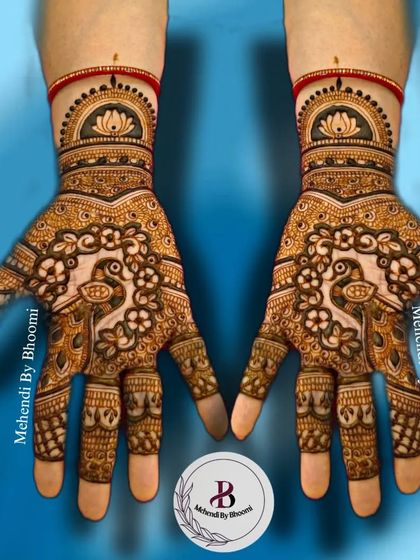 A symmetrical bridal design for the front of the hands. It features beautiful peacocks surrounded by floral patterns, with tiny elephants detailed on the fingers.