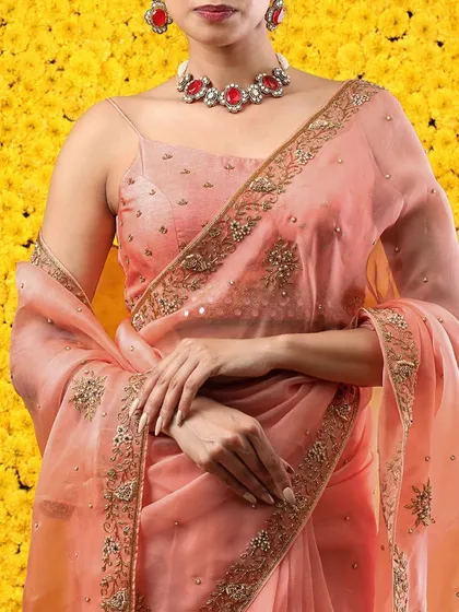 A close-up of the saree's embroidered border and the delicate buti work on the fabric.