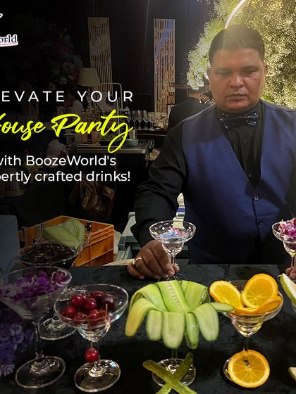 One of our expert bartenders is ready to elevate your house party. He stands behind a bar laden with fresh garnishes like cucumber, orange, and cherries, ready to craft custom drinks for your guests.