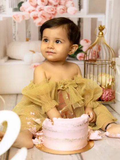 A close-up of the birthday girl enjoying her cake. The details matter, from the frosting on her face to the delicate tulle of her dress, it all adds to the memory.