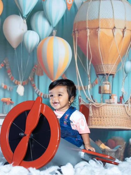A joyful pilot ready for adventure. The colorful hot air balloons in the background add to the whimsical feel.