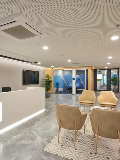 The reception area for an HDFC Life office in Lower Parel, Mumbai. The design is clean and contemporary, with a marble-finish floor, a sleek white desk with an illuminated logo, and a comfortable waiting lounge.