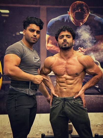 Posing with a client. His abs are shredded, a testament to his diet and training.