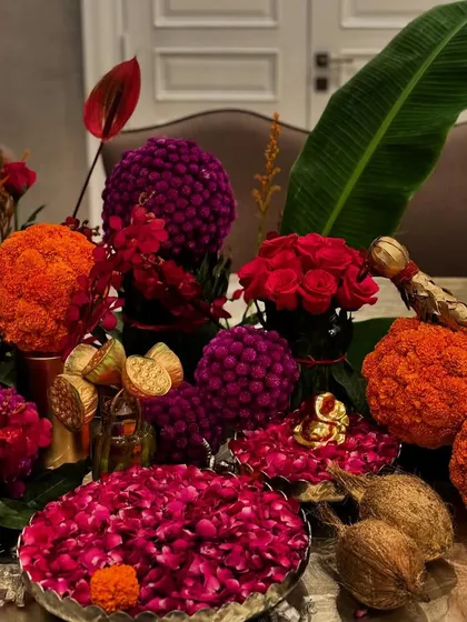 This Diwali flower decoration for a buffet table features bold marigold spheres, red roses, and bowls of fragrant petals. I love using traditional elements like coconuts and decorative birds to invite luxury into the home.