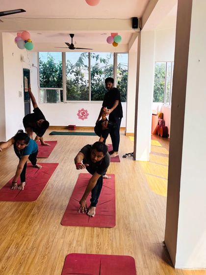 Students engaged in various standing poses like Parivrtta Trikonasana and Ardha Chandrasana, showcasing the dynamic nature of our group classes.