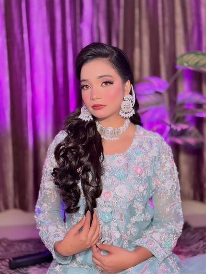 A portrait of Aira showing off her finished look. The pink-toned makeup and statement silver jewelry create a beautiful contrast, perfect for any festive occasion.