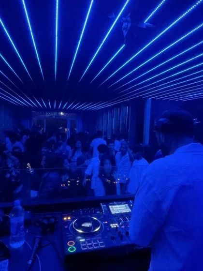 The blue-lit ceiling of Ice Cube Lounge creates a futuristic vibe as I command the dance floor.