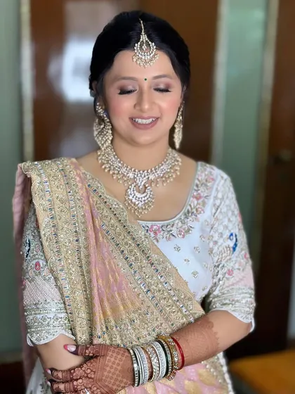 Bride Manjari's beautiful wedding look. The pastel colors of her lehenga are reflected in the soft, romantic makeup.