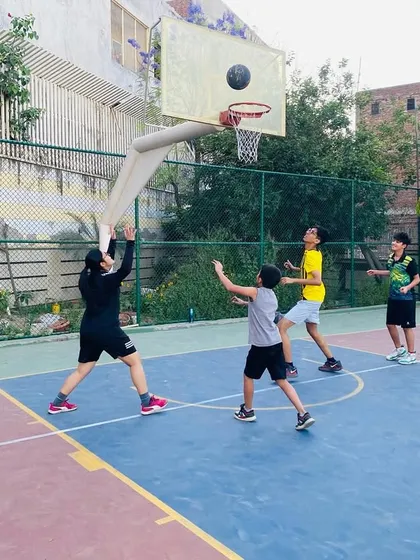 A female player attempts a jump shot, showcasing the shooting form we teach to all our athletes.