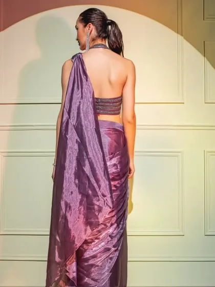 The back view of the metallic purple drape saree, showcasing the stylish halter-neck design of the embellished blouse.