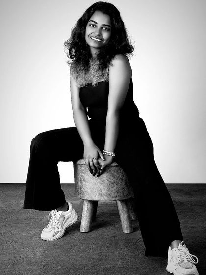 A full-body portrait in black and white can be incredibly powerful. This shot of a model in a simple black outfit and sneakers has a relaxed, modern, and confident feel, showcasing personality.
