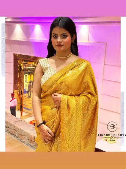 A full view of the client in her gorgeous gold saree. The makeup is designed to be glamorous and photogenic, ensuring she looks great all night.