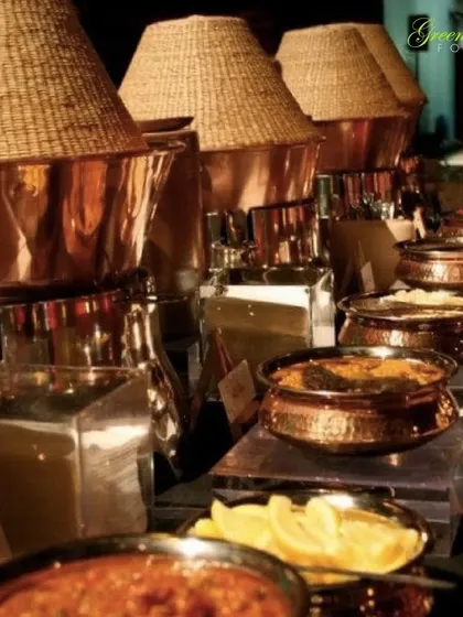 This buffet setup showcases our traditional Indian serving ware. The copper and brass dishes with unique woven lids add an authentic, rustic charm to the dining experience, perfect for serving our regional specialties.