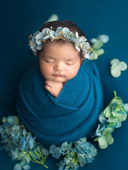 A perfect cocoon. This tight, secure wrap in a beautiful shade of blue keeps the baby feeling safe and allows for these serene, artistic shots.