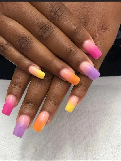 A vibrant, multi-colored ombre set. Each nail transitions through different bright colors, creating a fun, rainbow-like effect on these long square nails.