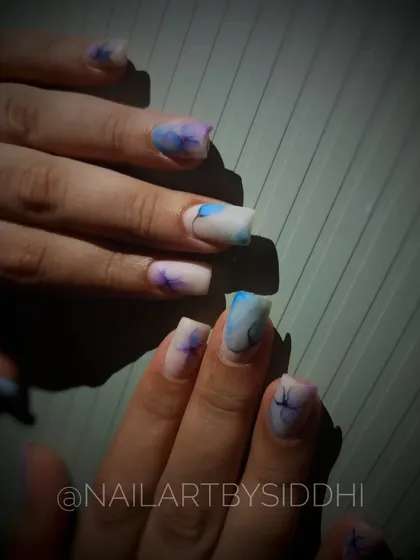 A soft, dreamy floral design with a watercolor effect in shades of blue and purple.