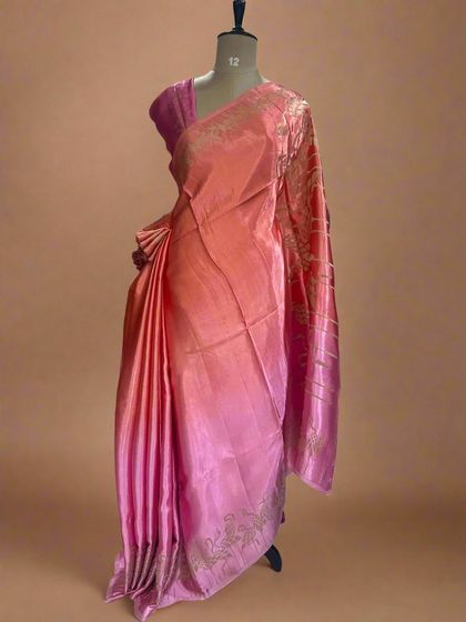 A lovely shaded satin crepe saree with a flamingo border in shades of peach and pink.