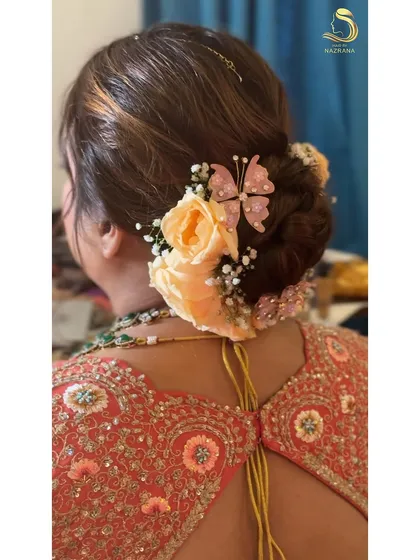A detailed shot of the butterfly and floral bun, showing the delicate placement of each element.