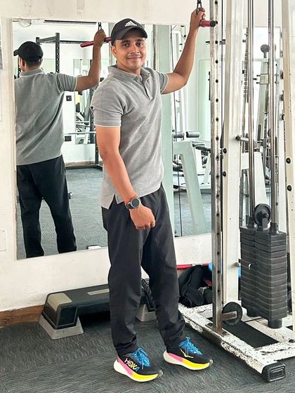 A relaxed pose by the cable machine after a set.