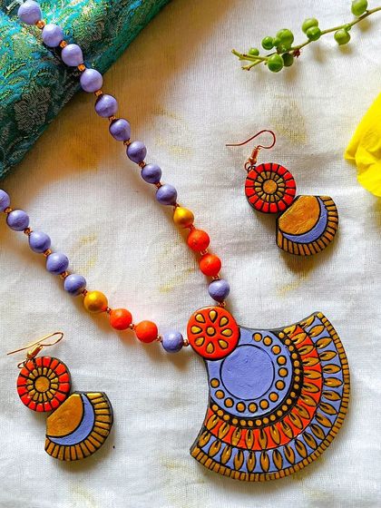 The same fan-shaped pendant design, here in a unique lavender and orange palette.