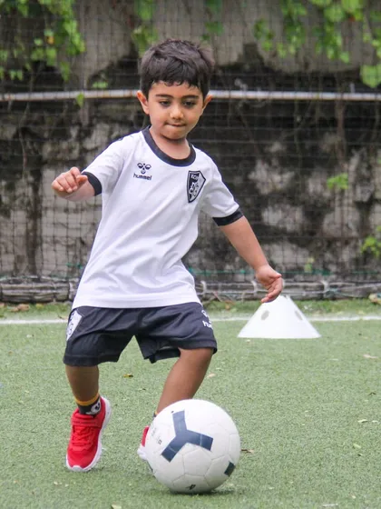 This player shows great concentration as he dribbles the ball, a testament to our focus on developing technical skills and a strong work ethic.