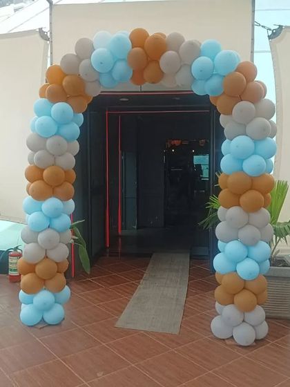 An outdoor balloon arch in blue, brown, and grey. This color combination is great for a rustic or teddy bear themed baby shower.