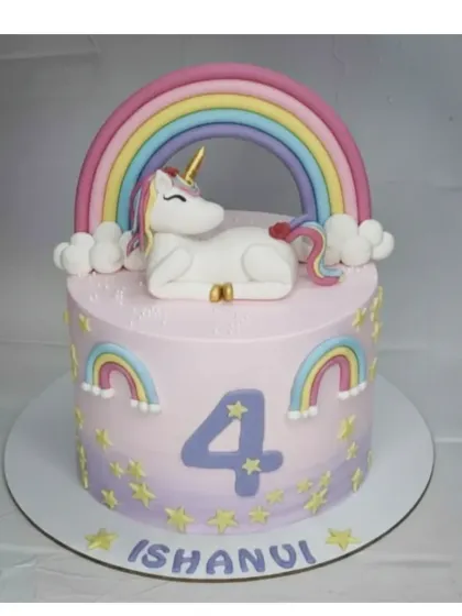 A magical unicorn cake for a 4th birthday. This basic vanilla cake is covered in light whipped cream and adorned with a detailed, handmade fondant unicorn and rainbow.