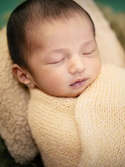 A close-up on the peaceful, sleeping face of our little golfer. I focus on capturing these serene details in my newborn photography.