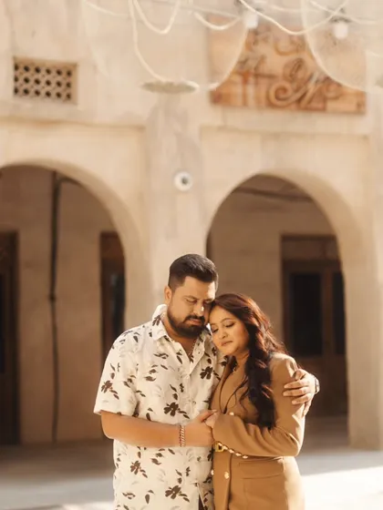 A quiet, tender embrace within the beautiful archways of a traditional Arabian souk. The soft light and historic setting create a deeply romantic and intimate portrait.