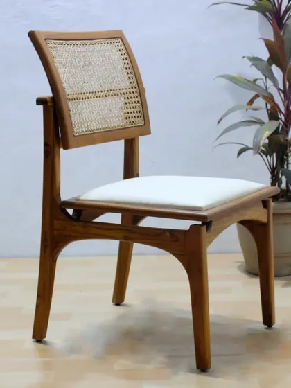 This dining chair design features a floating backrest supported by elegant wooden arms. It's a modern take on a classic cane chair.