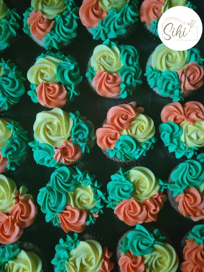 A vibrant and colorful batch of floral buttercream cupcakes. I used a mix of orange, yellow, and teal to create this cheerful and eye-catching design.