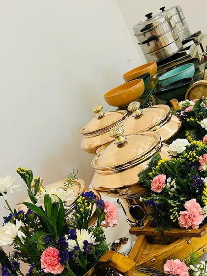 A vibrant buffet line decorated with colorful flowers and unique boat-shaped platters, showcasing our creative approach to food presentation for house parties.