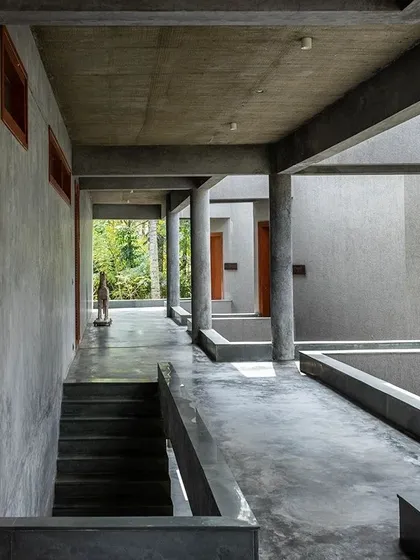 A corridor at the Anahaspa retreat, where the simple, robust concrete structure frames the natural beauty of the surrounding landscape.
