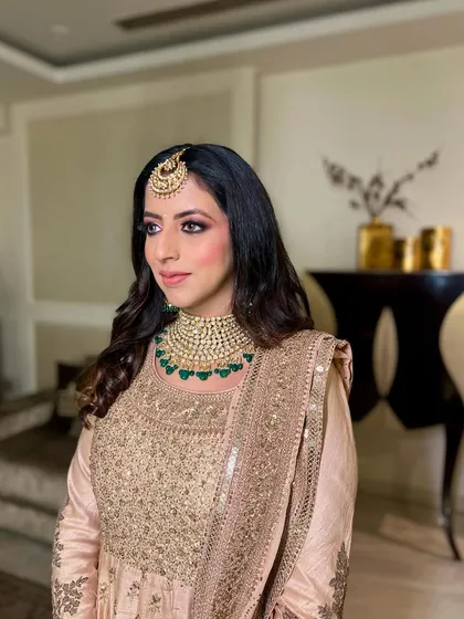 A side profile, showing the beautiful details of her makeup and jewelry.