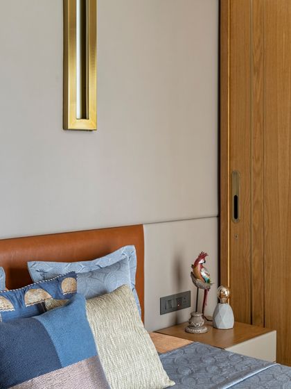 Another angle of the bedside table in the Filigree House, highlighting the warm lighting and curated decor. The blend of leather, wood, and soft fabrics exudes simple elegance.