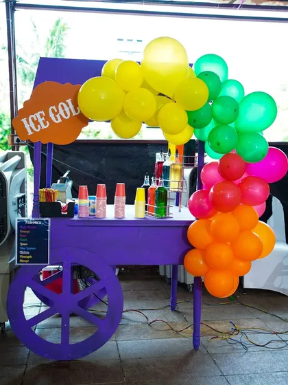 An "Ice Gola" cart in a vibrant purple, serving up refreshing flavored ice treats to cool down the guests.