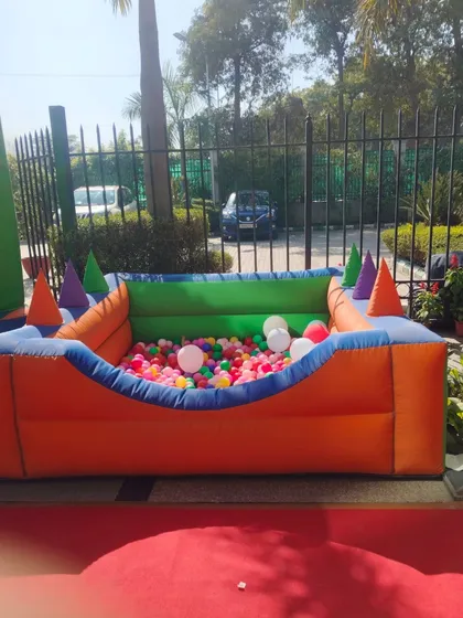 This outdoor setup shows the ball pool ready for action at a family event, placed on a protective mat for cleanliness and safety.