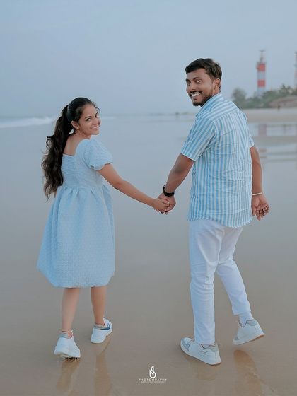 A lovely "follow me" shot on the wet sand at dusk, with a lighthouse visible in the distance, adding a classic coastal element.