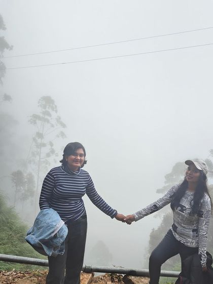 Two friends holding hands in the misty Kodaikanal hills.
