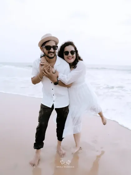 A happy, carefree portrait of the couple embracing on the beach, their smiles as bright as the day.