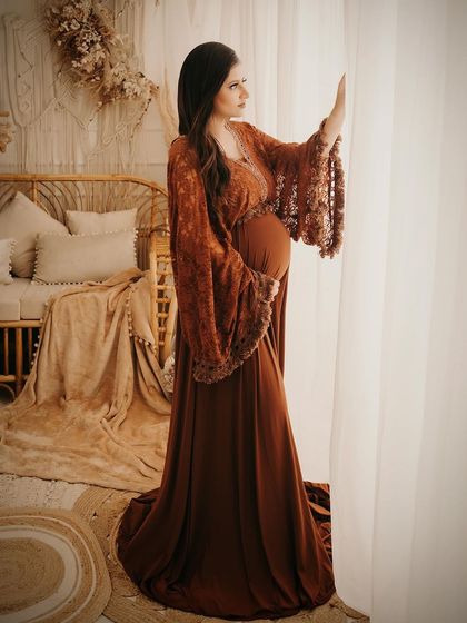 A contemplative moment in our rustic boho bedroom setup. The warm, diffused light from the window and the natural textures of the decor create a cozy and intimate mood.