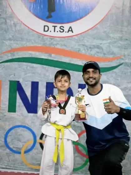This student's smile says it all. He fought hard and won his medal and trophy at the Siri Fort sports complex competition.