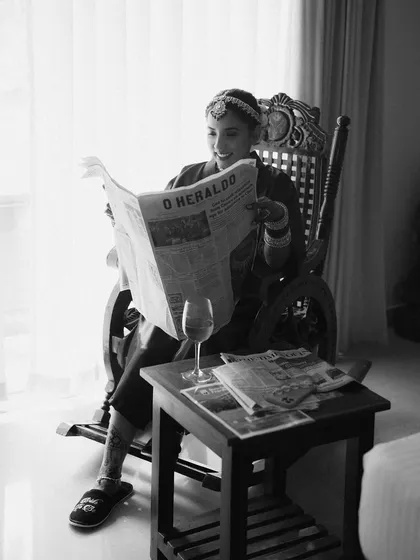 A candid version of the editorial bridal portrait. The bride's smile as she reads the paper adds a layer of warmth and personality to the creative concept.