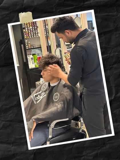 Our stylist meticulously working on the client's curly hair, ensuring every detail is perfect for the final look.