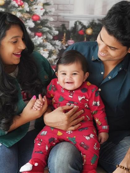A beautiful family enjoying their baby's first Christmas photoshoot. The smiles and loving gazes say it all.