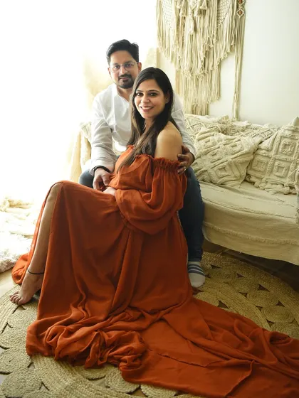 A full-length view showing the beautiful flow of the rust-colored gown. This setup is perfect for creating a relaxed, earthy, and bohemian vibe for your maternity pictures.